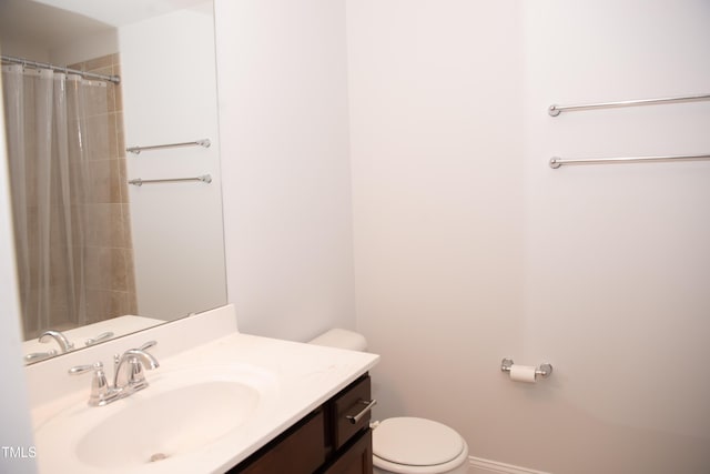 bathroom with vanity, curtained shower, and toilet