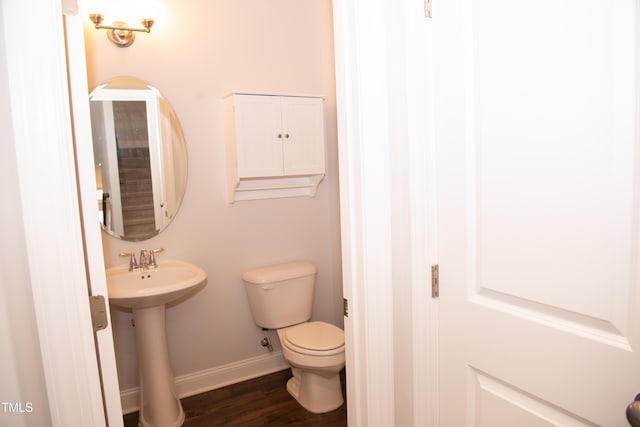 bathroom with hardwood / wood-style flooring, toilet, and sink