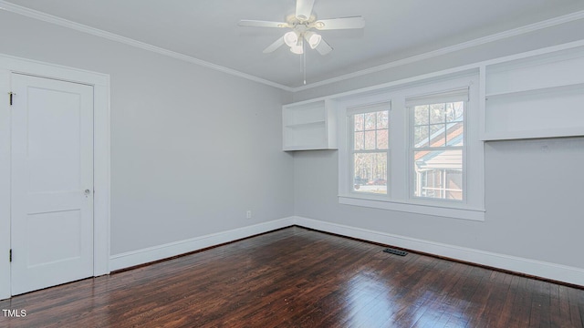 spare room with ornamental molding, dark wood finished floors, and baseboards