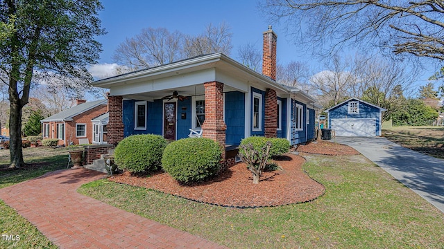 view of home's exterior with a lawn, a ceiling fan, a chimney, an outbuilding, and a porch