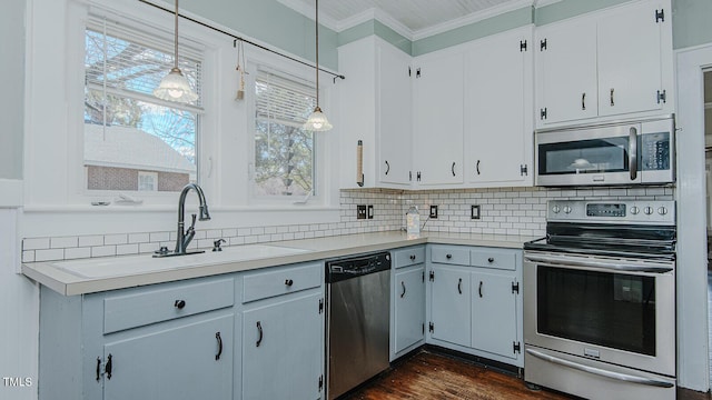 kitchen featuring appliances with stainless steel finishes, light countertops, ornamental molding, and tasteful backsplash