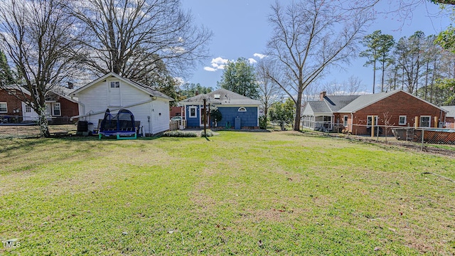 view of yard featuring a trampoline and a fenced backyard