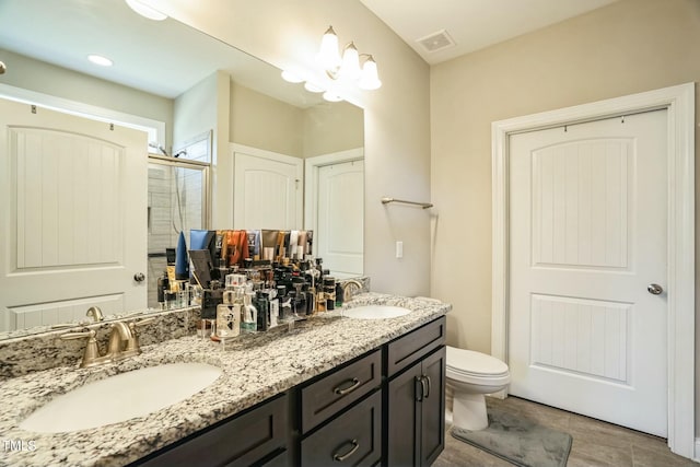 bathroom with a chandelier, vanity, toilet, and a shower with shower door