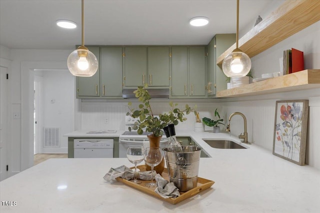 kitchen with green cabinets, dishwasher, sink, and hanging light fixtures