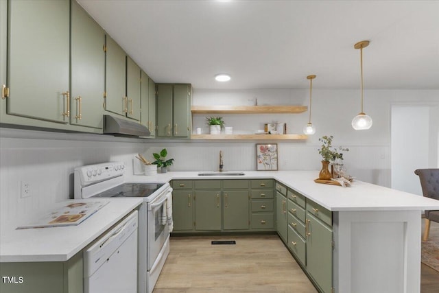 kitchen with sink, decorative light fixtures, kitchen peninsula, green cabinets, and white appliances