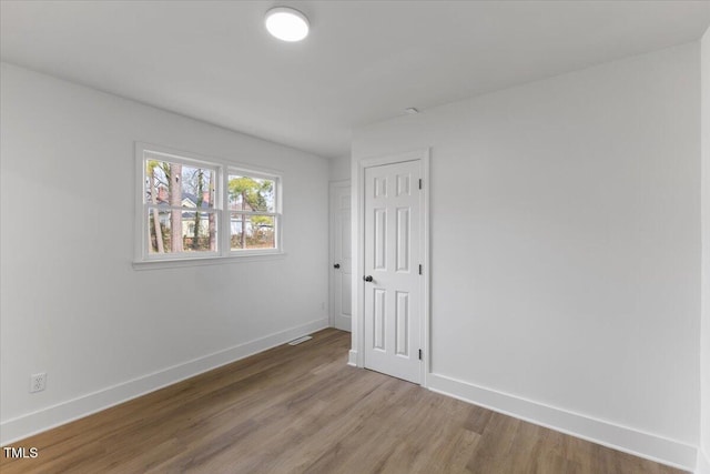 unfurnished room with wood-type flooring