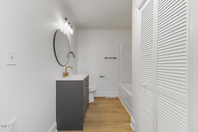 bathroom featuring vanity, hardwood / wood-style flooring, and toilet