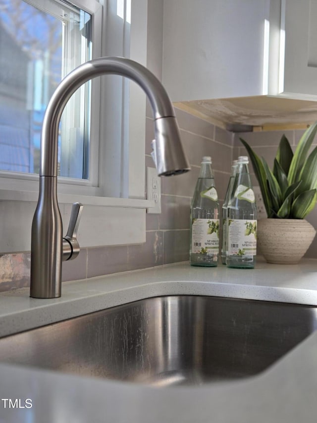 details featuring sink and decorative backsplash