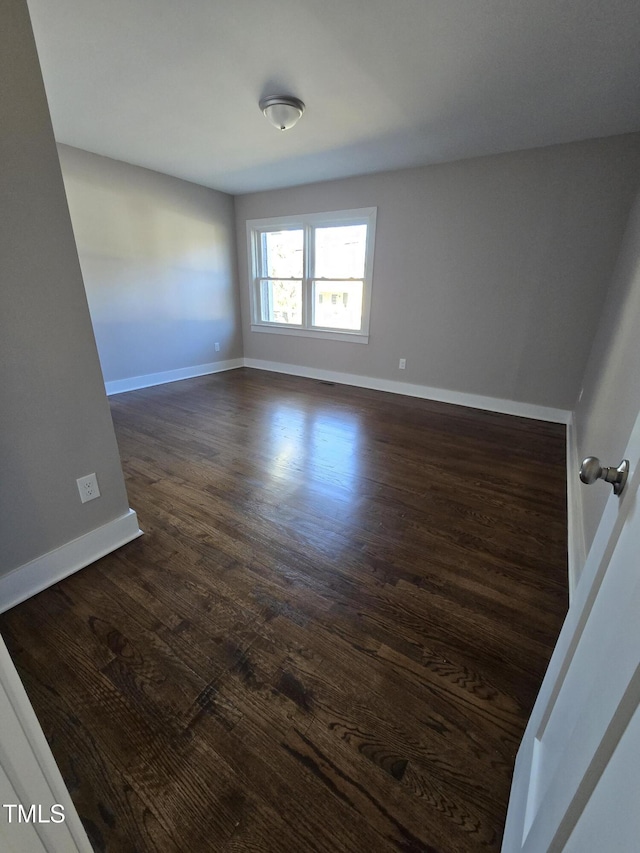 empty room with dark hardwood / wood-style flooring