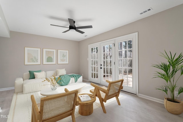 sitting room with ceiling fan, light wood-type flooring, and french doors