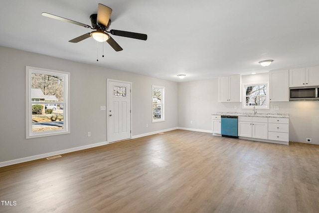 kitchen featuring sink, light wood-type flooring, stainless steel appliances, light stone countertops, and white cabinets