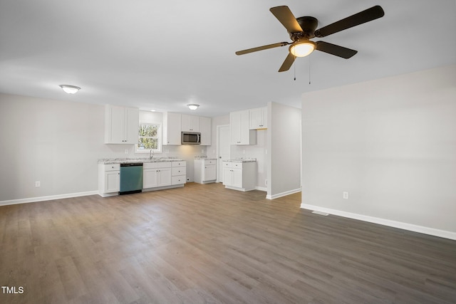 unfurnished living room featuring ceiling fan, sink, and hardwood / wood-style floors