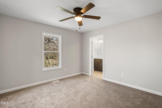 unfurnished bedroom featuring ensuite bath, ceiling fan, and carpet