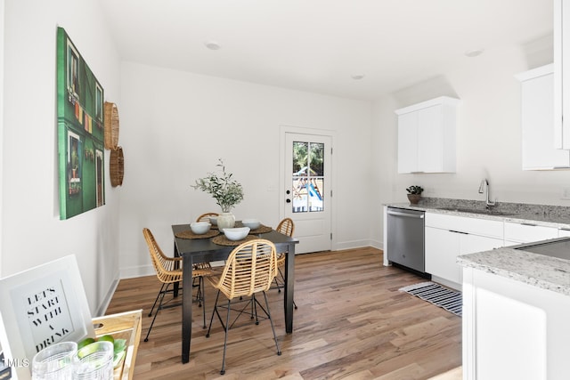 dining space with light hardwood / wood-style floors and sink