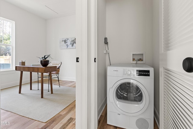 clothes washing area with wood-type flooring and washer / clothes dryer