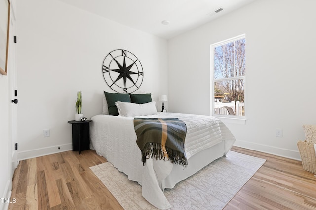 bedroom with multiple windows and light wood-type flooring