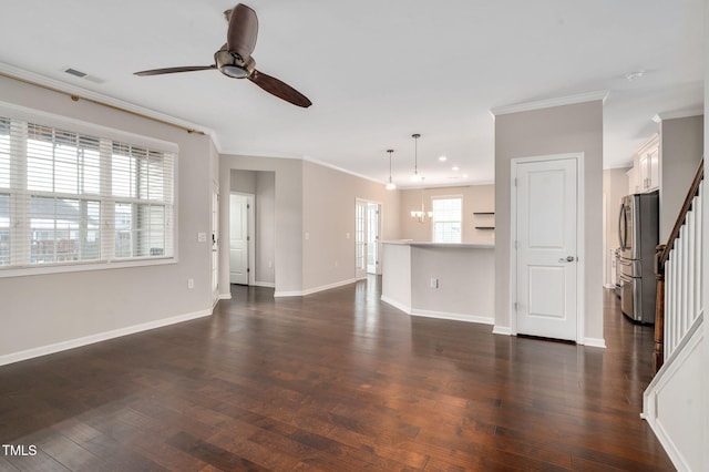 unfurnished living room with dark wood-type flooring, crown molding, and ceiling fan with notable chandelier