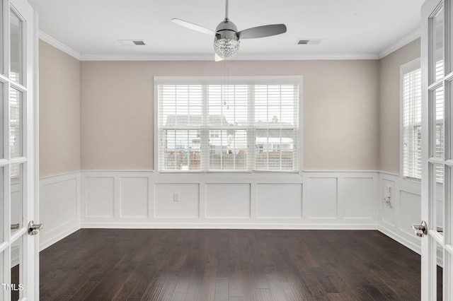 empty room featuring a healthy amount of sunlight, dark hardwood / wood-style floors, and french doors