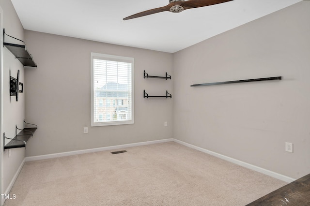 spare room featuring light colored carpet and ceiling fan