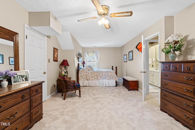 carpeted bedroom with ceiling fan, connected bathroom, and a textured ceiling