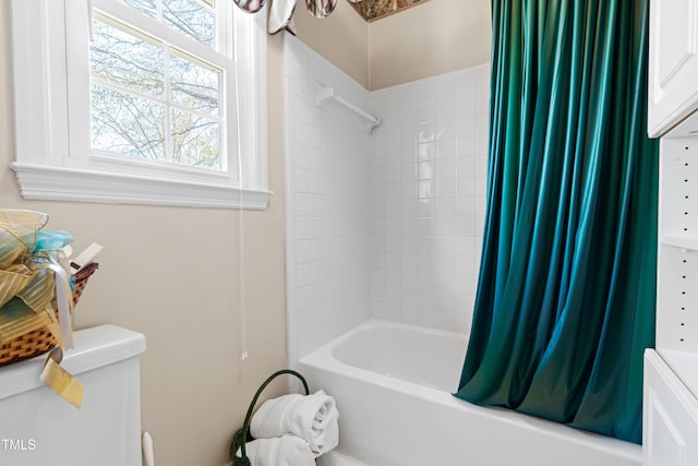 bathroom with shower / tub combo with curtain and toilet