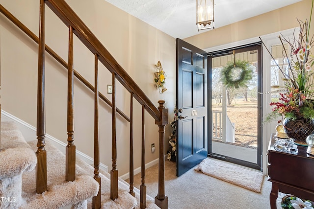 carpeted foyer entrance featuring a wealth of natural light and a textured ceiling