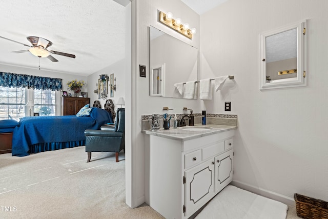 bathroom with vanity, ceiling fan, and a textured ceiling