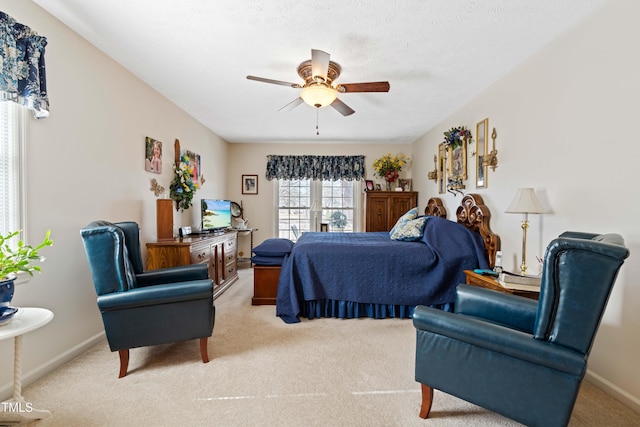 carpeted bedroom with ceiling fan and a textured ceiling