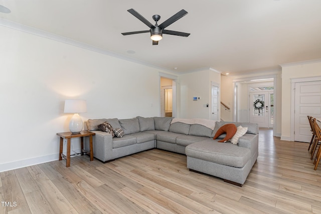 living room featuring ornamental molding, light hardwood / wood-style floors, and ceiling fan