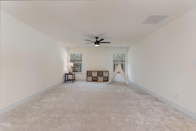 unfurnished room with light colored carpet and ceiling fan