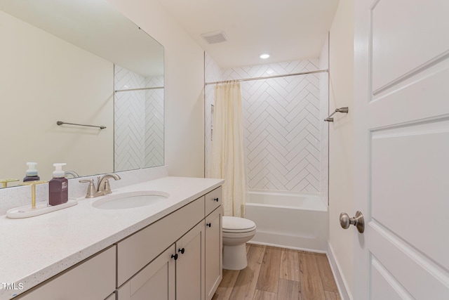 full bathroom with shower / tub combo, vanity, wood-type flooring, and toilet