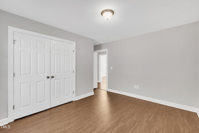 unfurnished bedroom with hardwood / wood-style floors and a closet