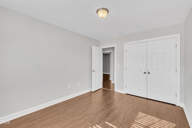 unfurnished bedroom with wood-type flooring and a closet