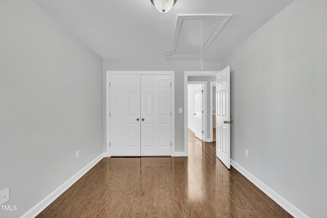 unfurnished bedroom featuring a closet and dark hardwood / wood-style floors