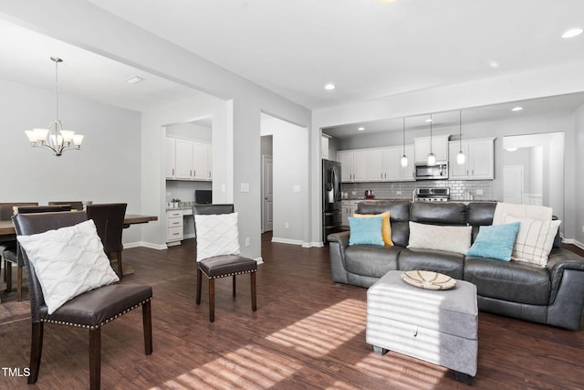 living room with baseboards, dark wood finished floors, a notable chandelier, and recessed lighting