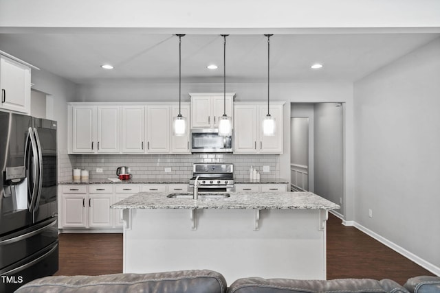 kitchen featuring appliances with stainless steel finishes, white cabinetry, and backsplash