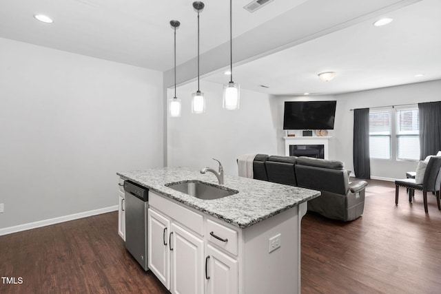 kitchen with visible vents, dark wood-style flooring, a sink, a fireplace, and stainless steel dishwasher