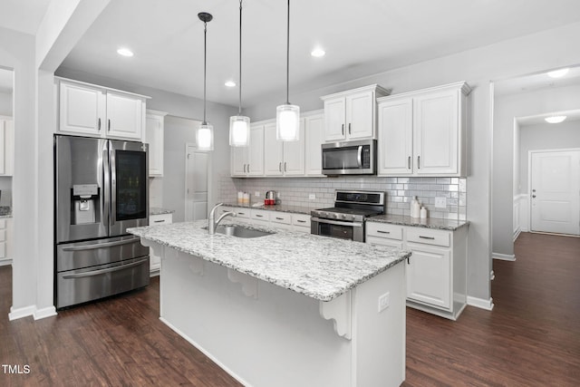 kitchen featuring appliances with stainless steel finishes, a kitchen island with sink, white cabinets, and a sink