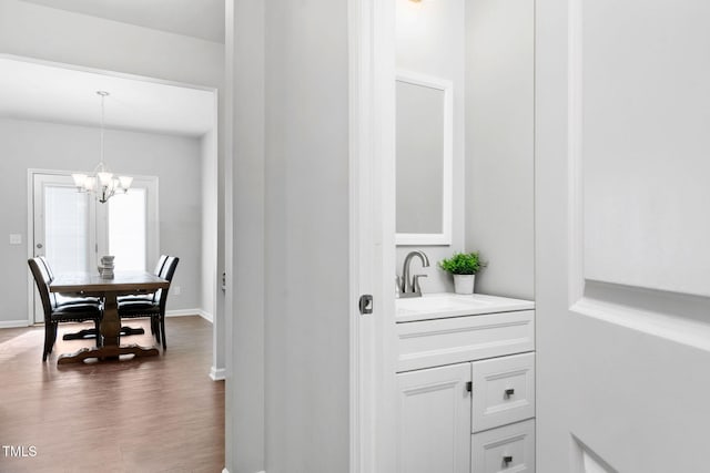 interior space with a notable chandelier, baseboards, a sink, and decorative light fixtures