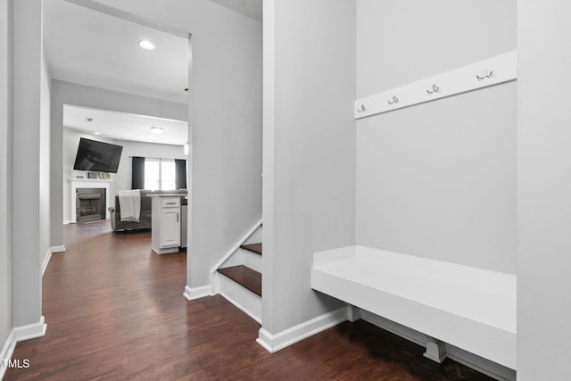 mudroom with a fireplace, baseboards, dark wood-type flooring, and recessed lighting