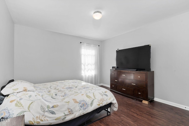 bedroom featuring dark wood-style flooring and baseboards