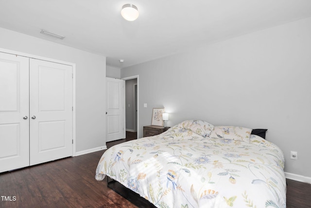 bedroom featuring a closet, visible vents, baseboards, and wood finished floors