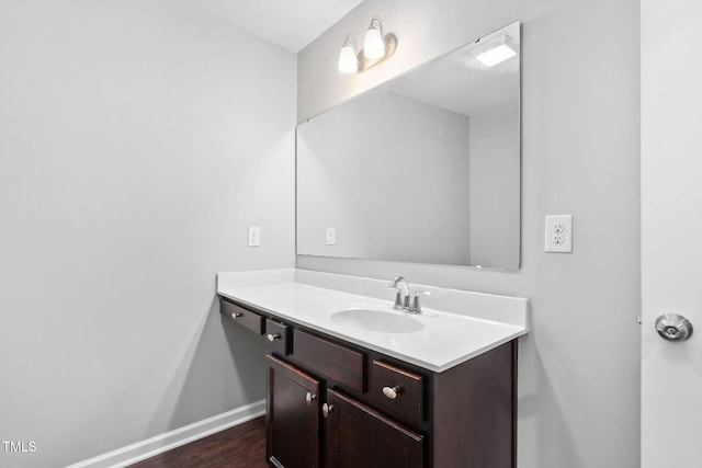 bathroom featuring baseboards, wood finished floors, and vanity