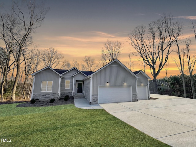 view of front of home with a garage, stone siding, a lawn, and board and batten siding