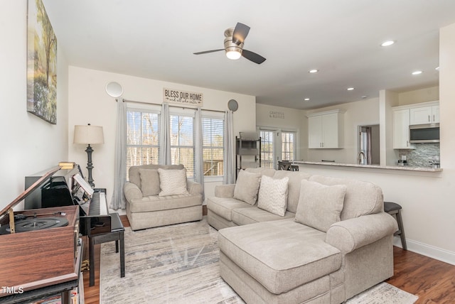 living room with a ceiling fan, recessed lighting, baseboards, and wood finished floors