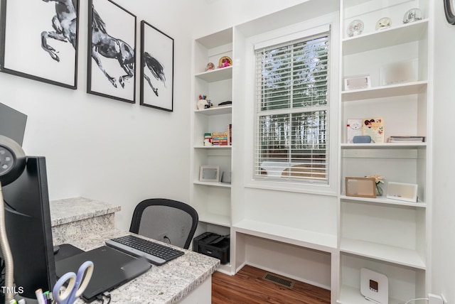 office featuring wood finished floors, visible vents, and built in features