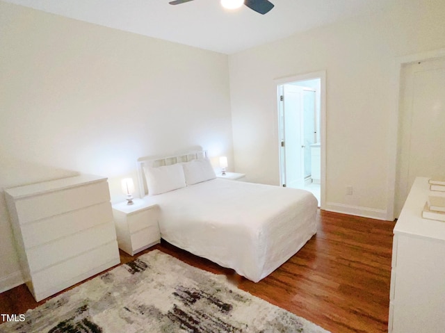 bedroom featuring a ceiling fan, baseboards, wood finished floors, and ensuite bathroom