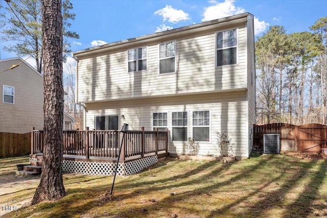 back of property with cooling unit, a yard, and a deck