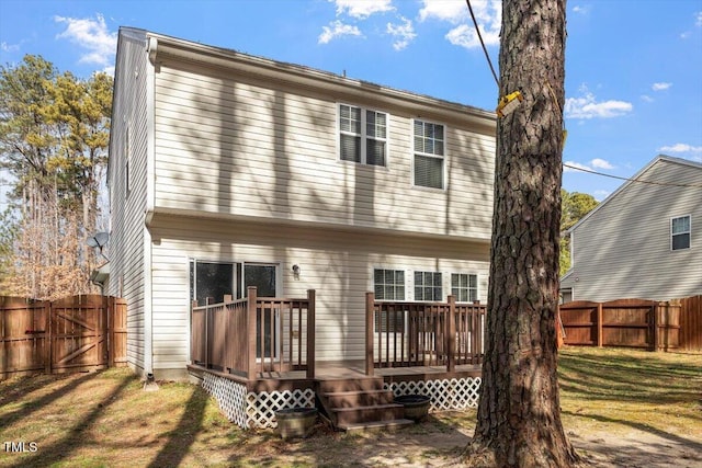 back of house featuring a wooden deck and a lawn