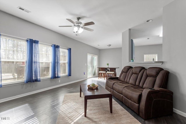 living room featuring ceiling fan and dark hardwood / wood-style flooring